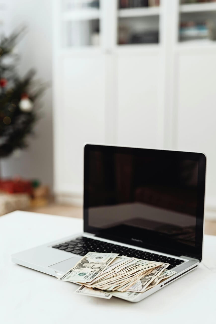 laptop with dollar bills